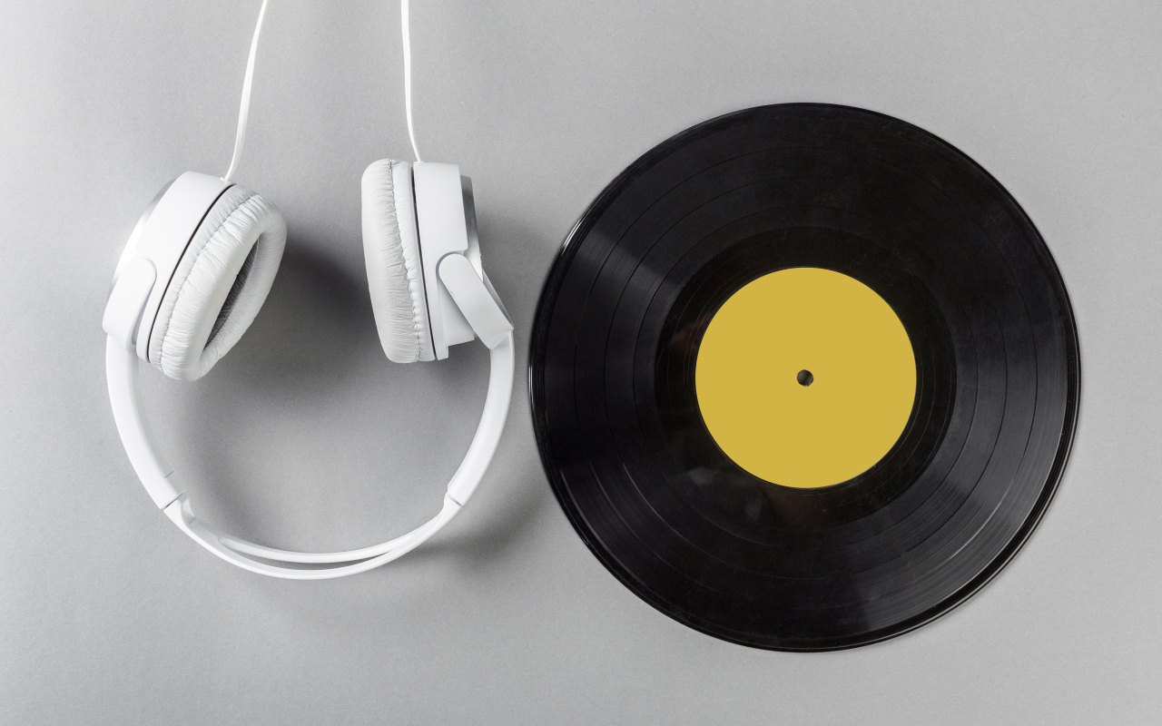 Черная пластинка и наушники на сером фоне