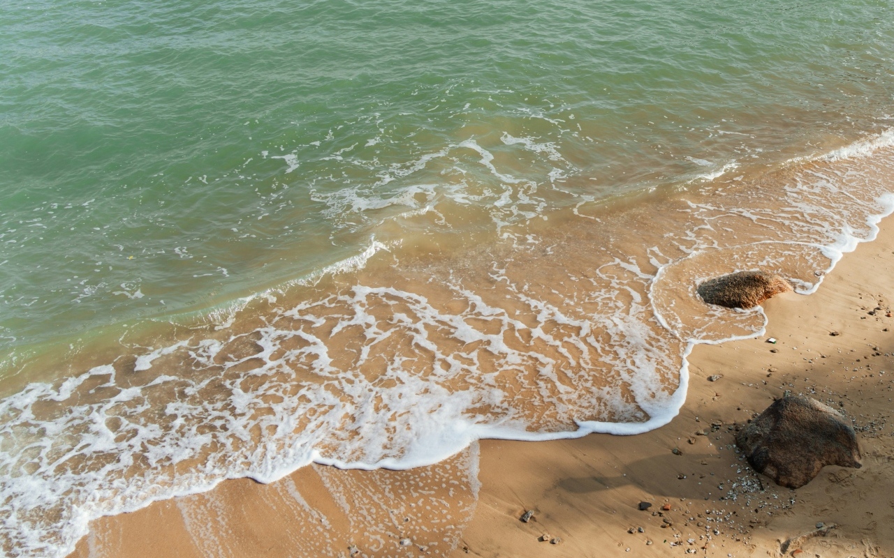 Красивая бирюзовая морская вода с белой пеной на песке