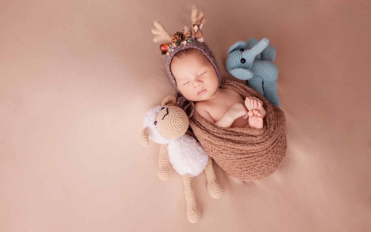 Маленький ребенок в костюме оленя с игрушкой