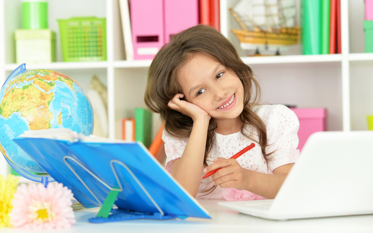 Улыбающаяся школьница делает уроки
