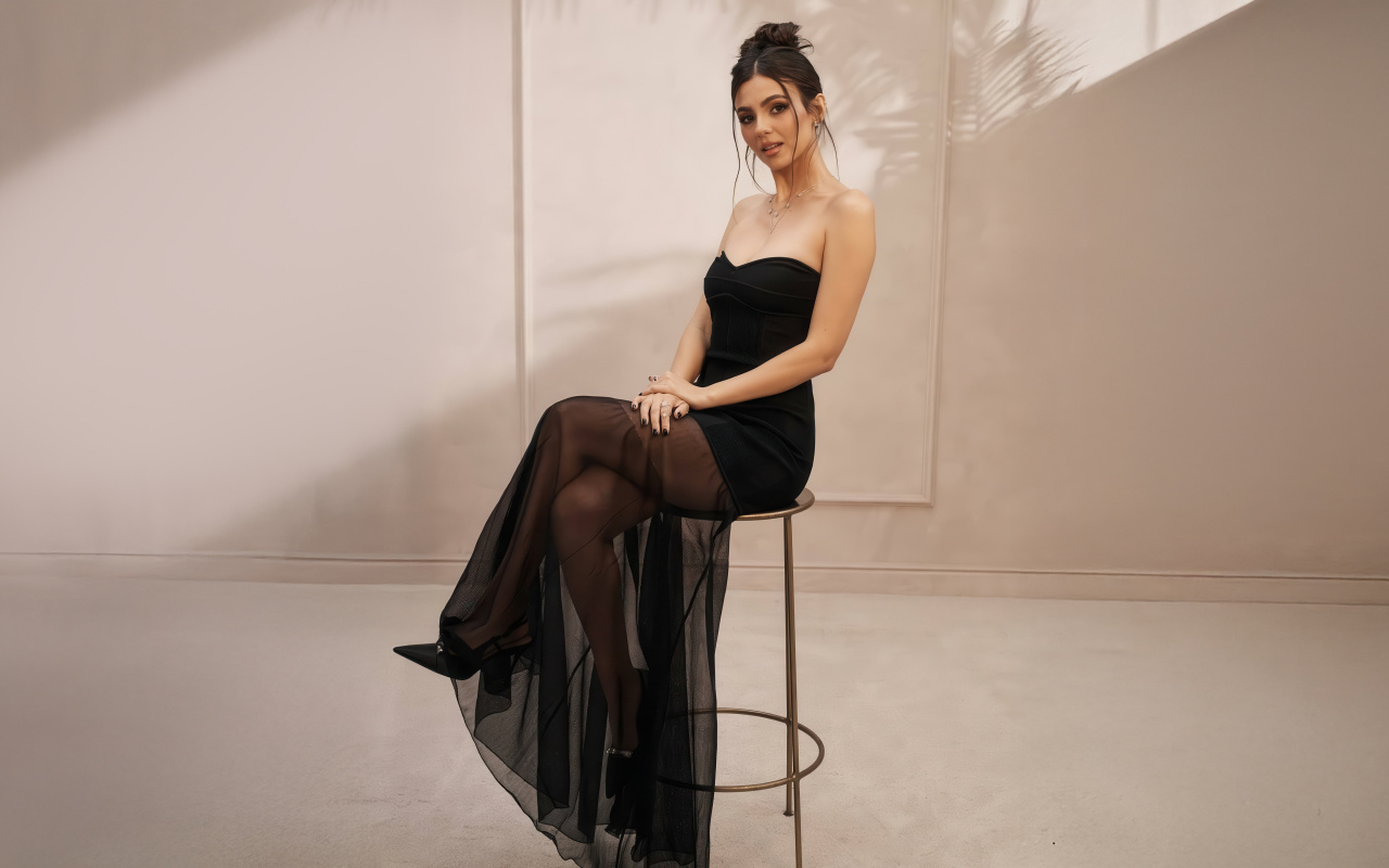 Американская актриса Виктория Джастис в черном платье на стуле