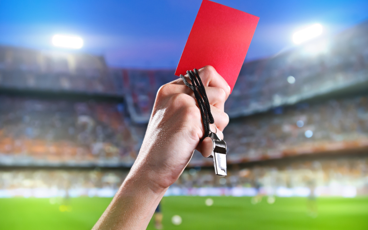 Свисток тренера и красная карточка в руке