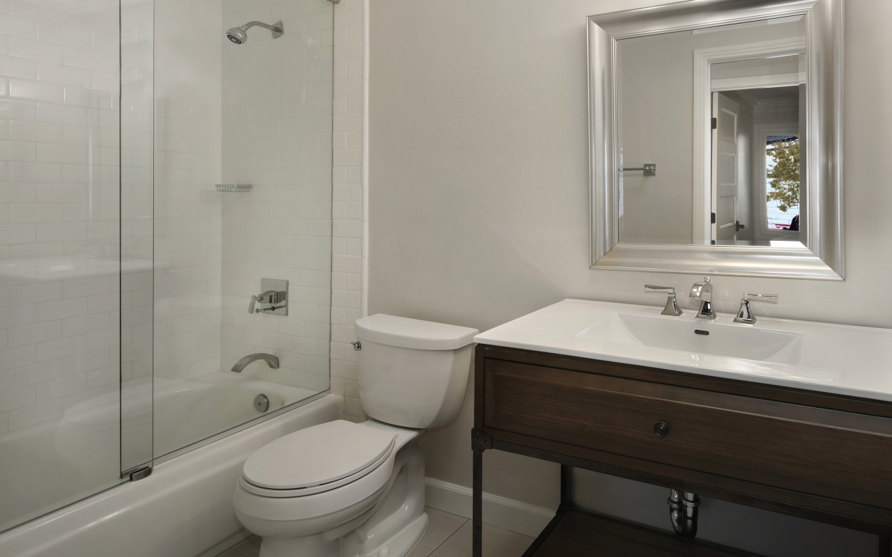 Интерьер ванной комнаты в белом цвете с душевой кабиной и унитазом