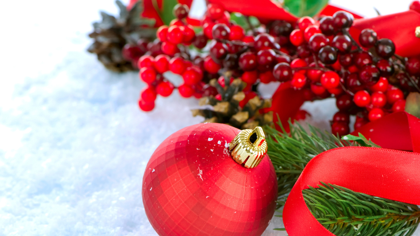 Красные ёлочные украшения на снегу