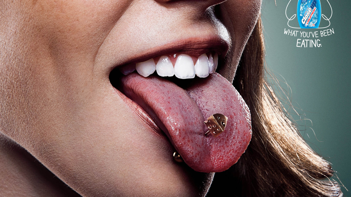 Девушка брюнетка с пирсингом в языке