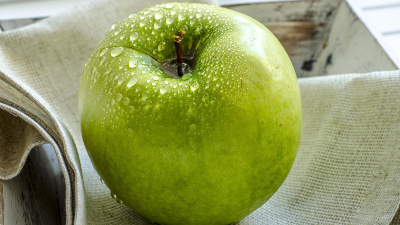 Влажное яблоко на холсте