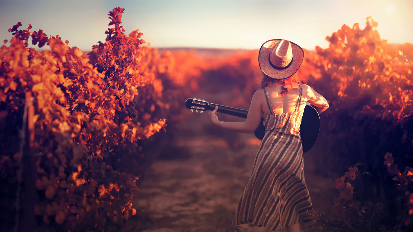 Девушка с гитарой в винограднике