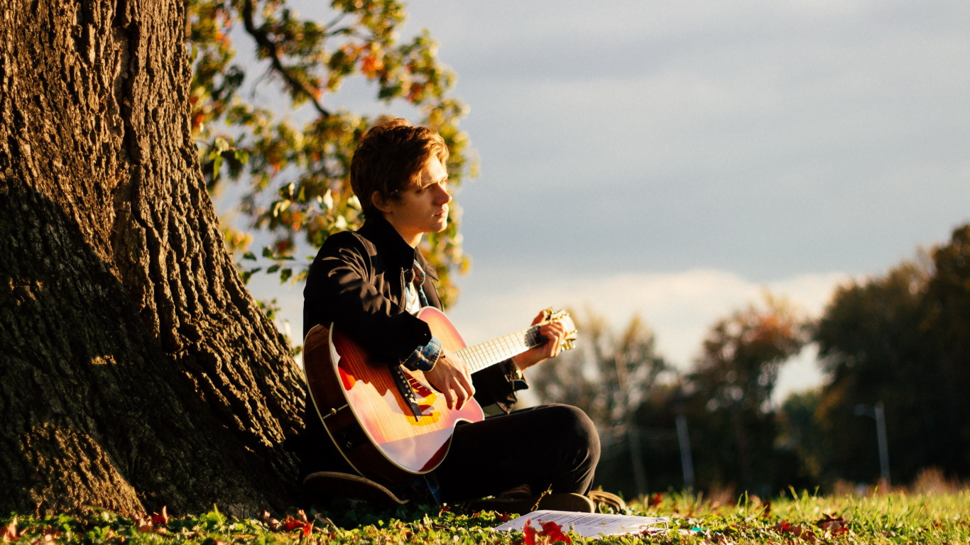 Парень с гитарой у дерева