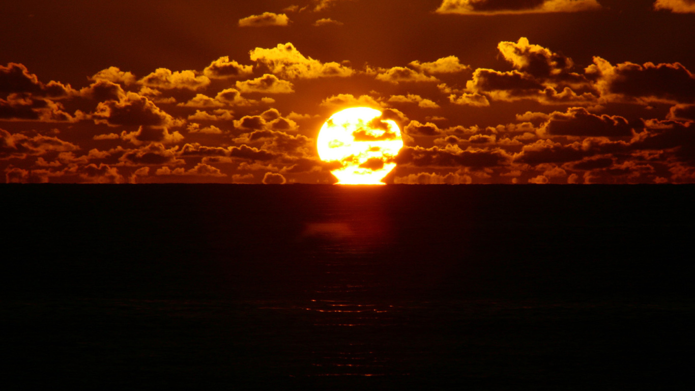 Солнце между небом и морем