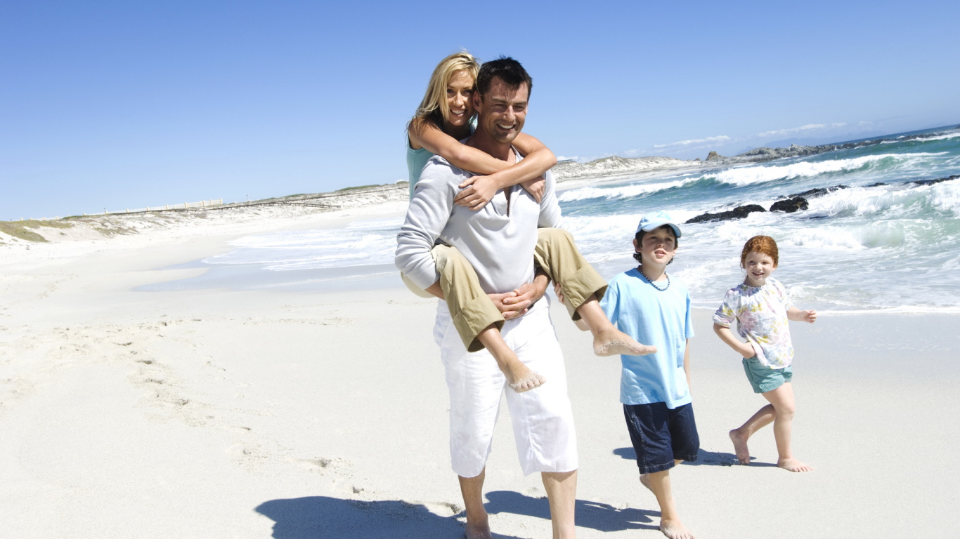 Семья гуляет по берегу