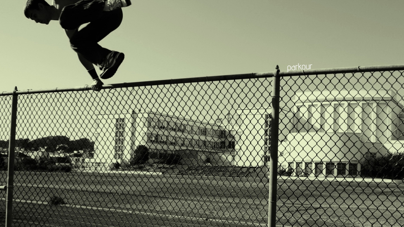Паркурщик прыгает через забор