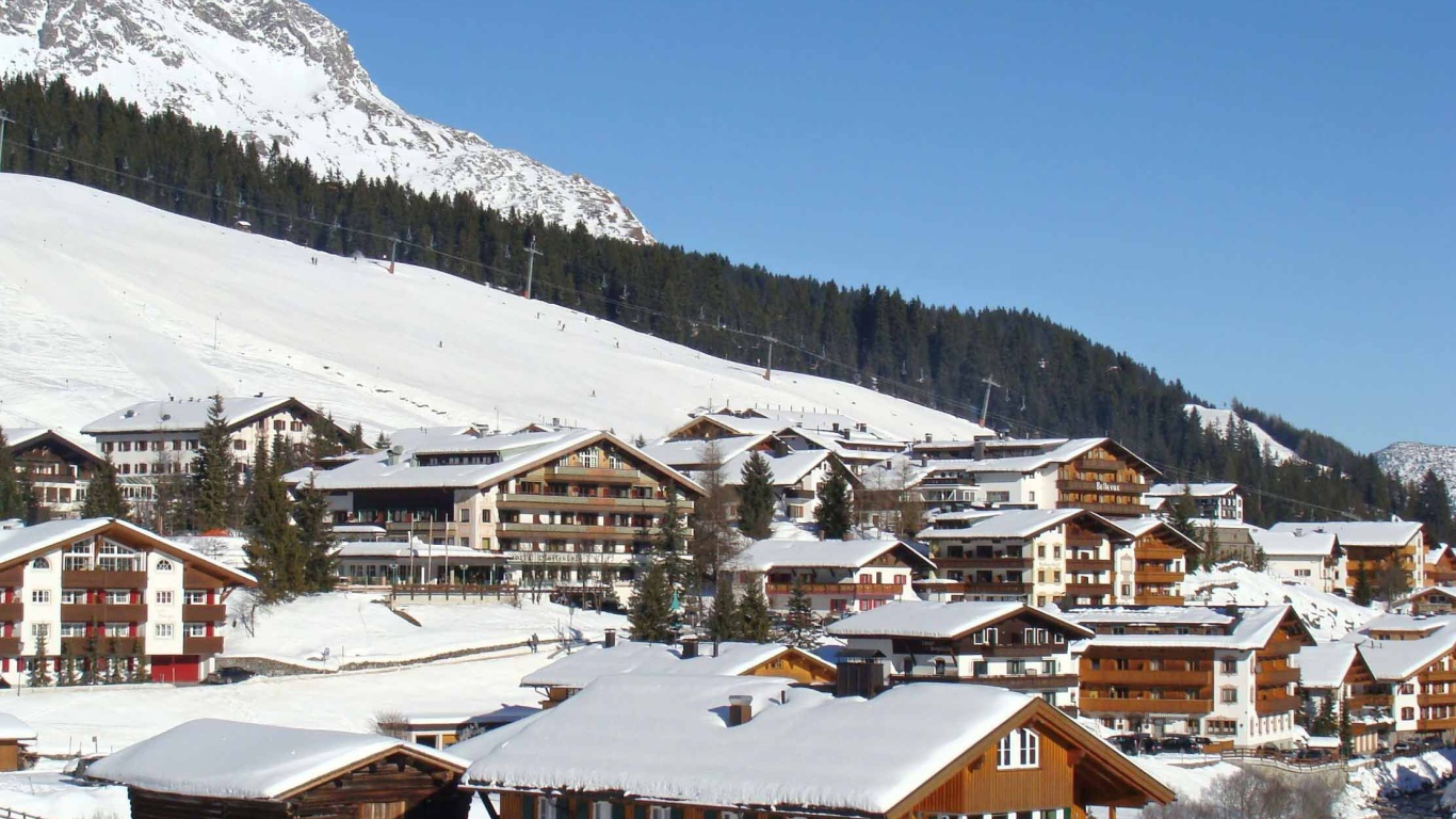 Дома на фоне гор на горнолыжном курорте Лех, Австрия