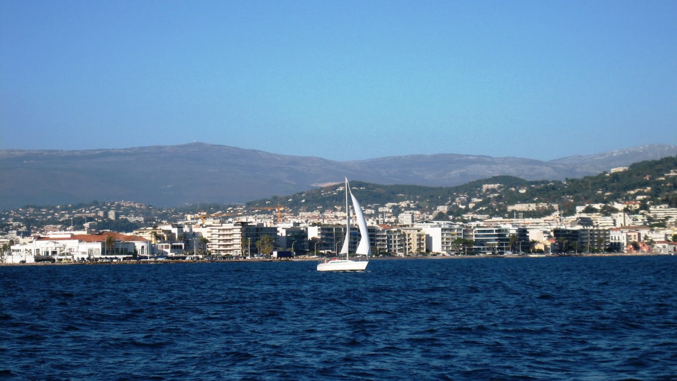 Яхта на фоне города на курорте Порт Де Фрежюс, Франция