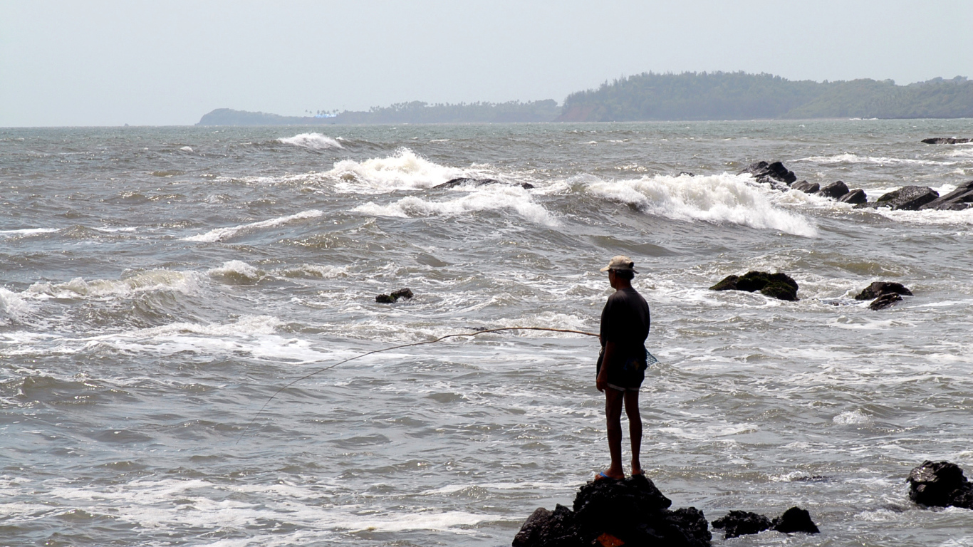 Мужчина ловит рыбу в Гоа