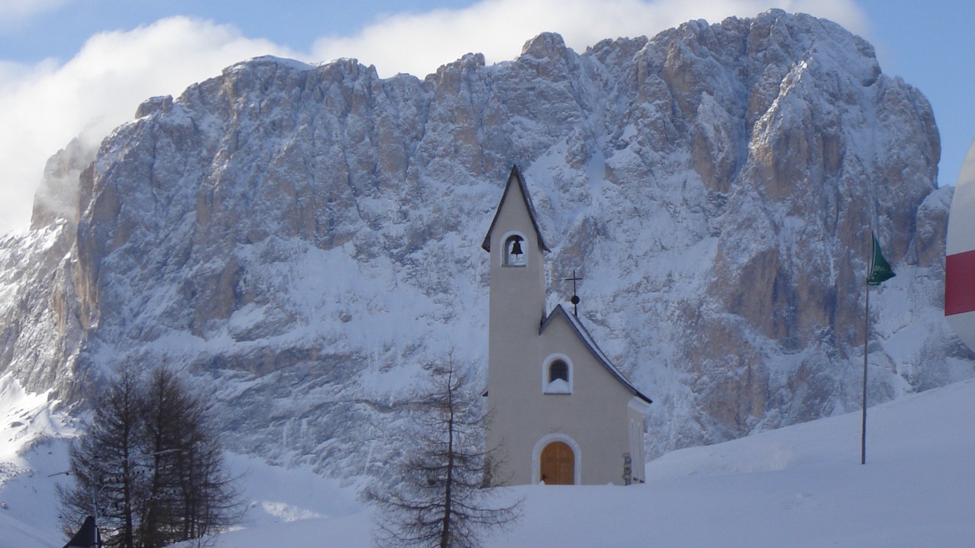 Церковь на фоне Альп на горнолыжном курорте Валь Гардена, Италия