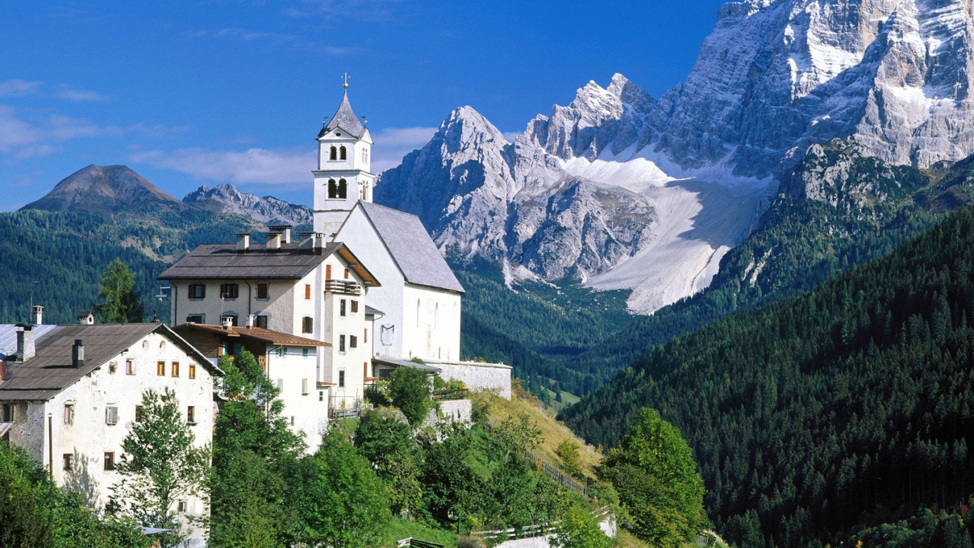 Дома на фоне гор на горнолыжном курорте Кортина д'Ампеццо, Италия