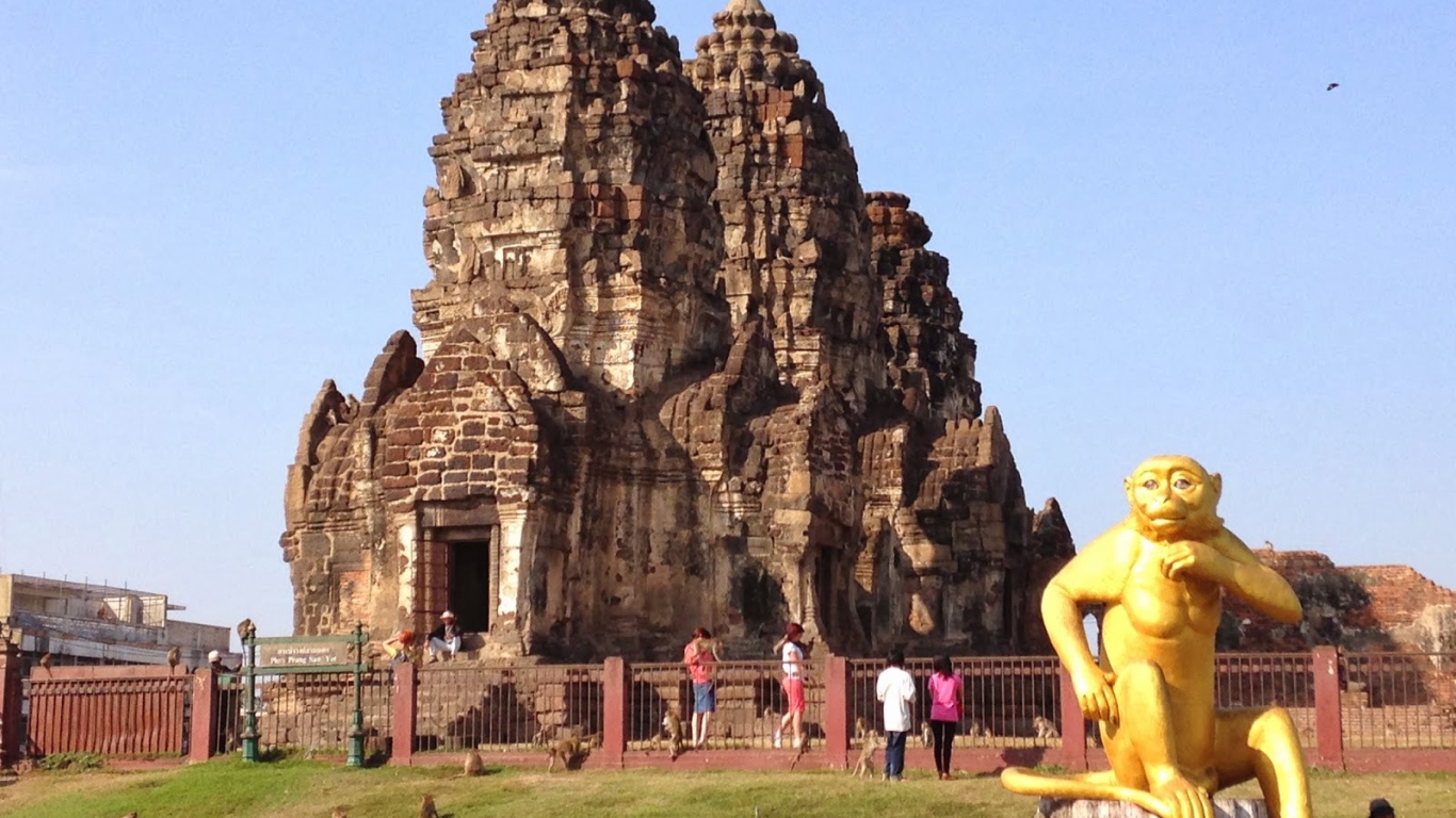 Золотая обезьяна на фоне храма на курорте Лопбури, Таиланд