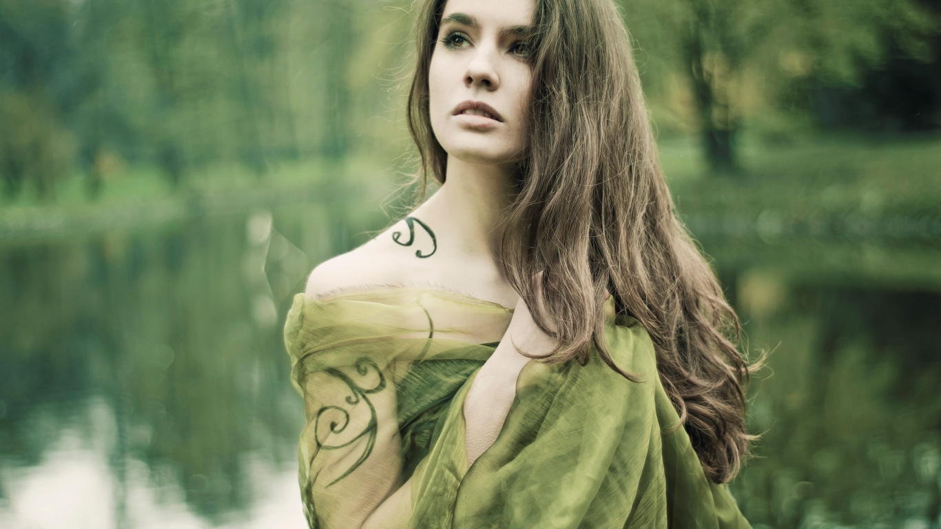 Девушка на природе с татуировкой на руке