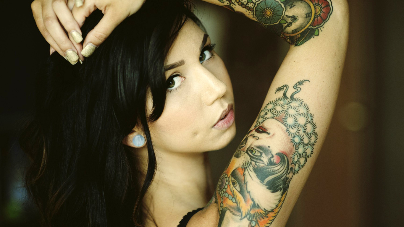 Черноволосая девушка с татуировкой на руке
