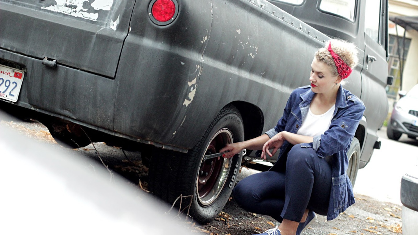 Девушка чинит автомобиль