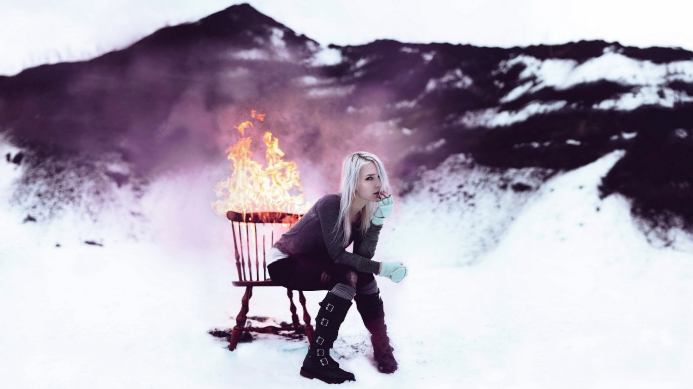 Девушка сидит на горящем стуле