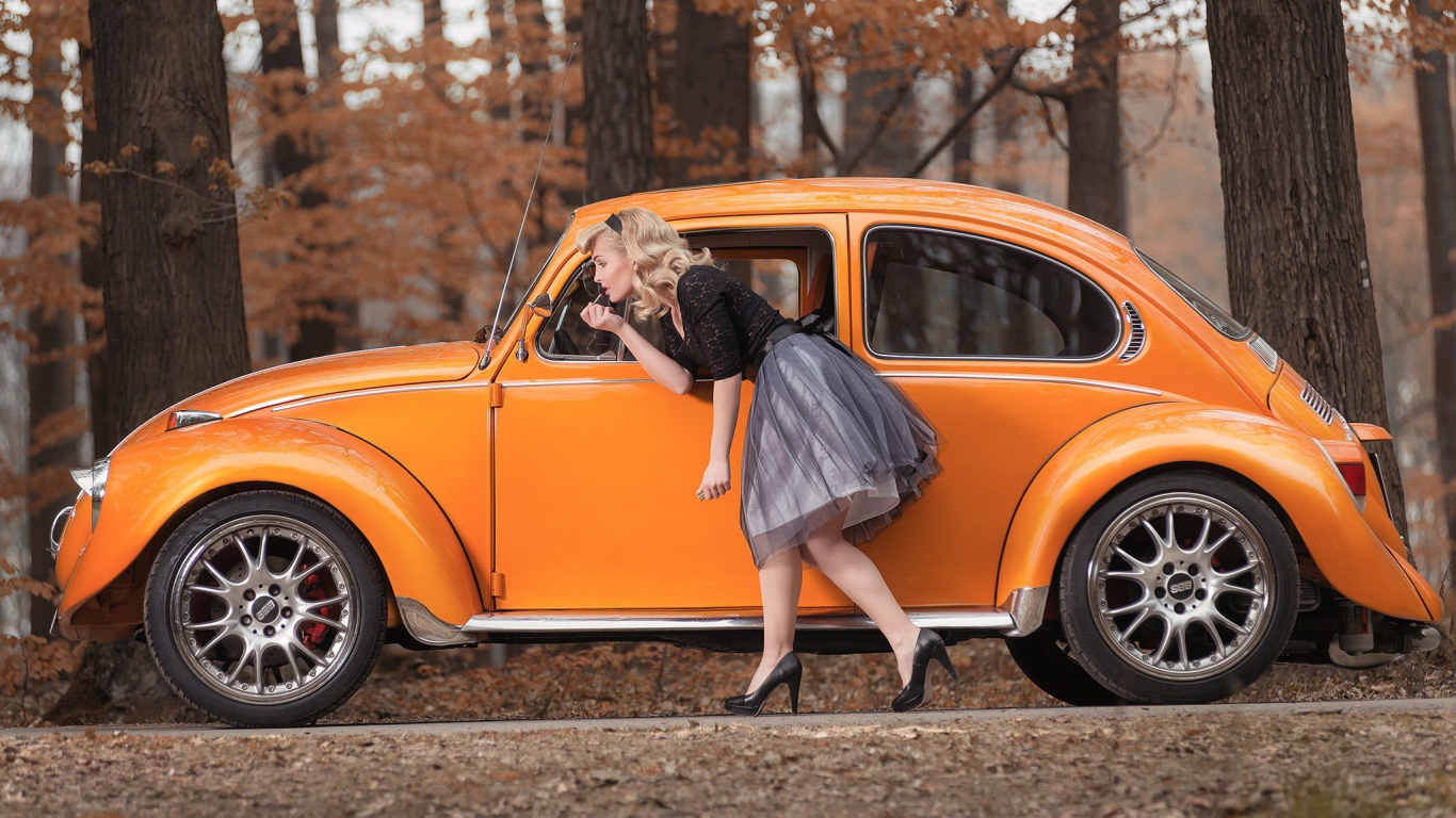 Девушка красит губы у зеркала старого автомобиля