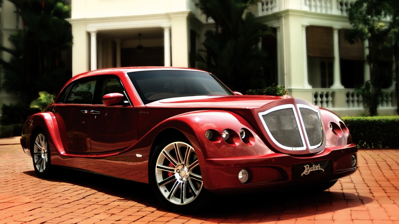 Красный роскошный автомобиль на мощеной дорожке