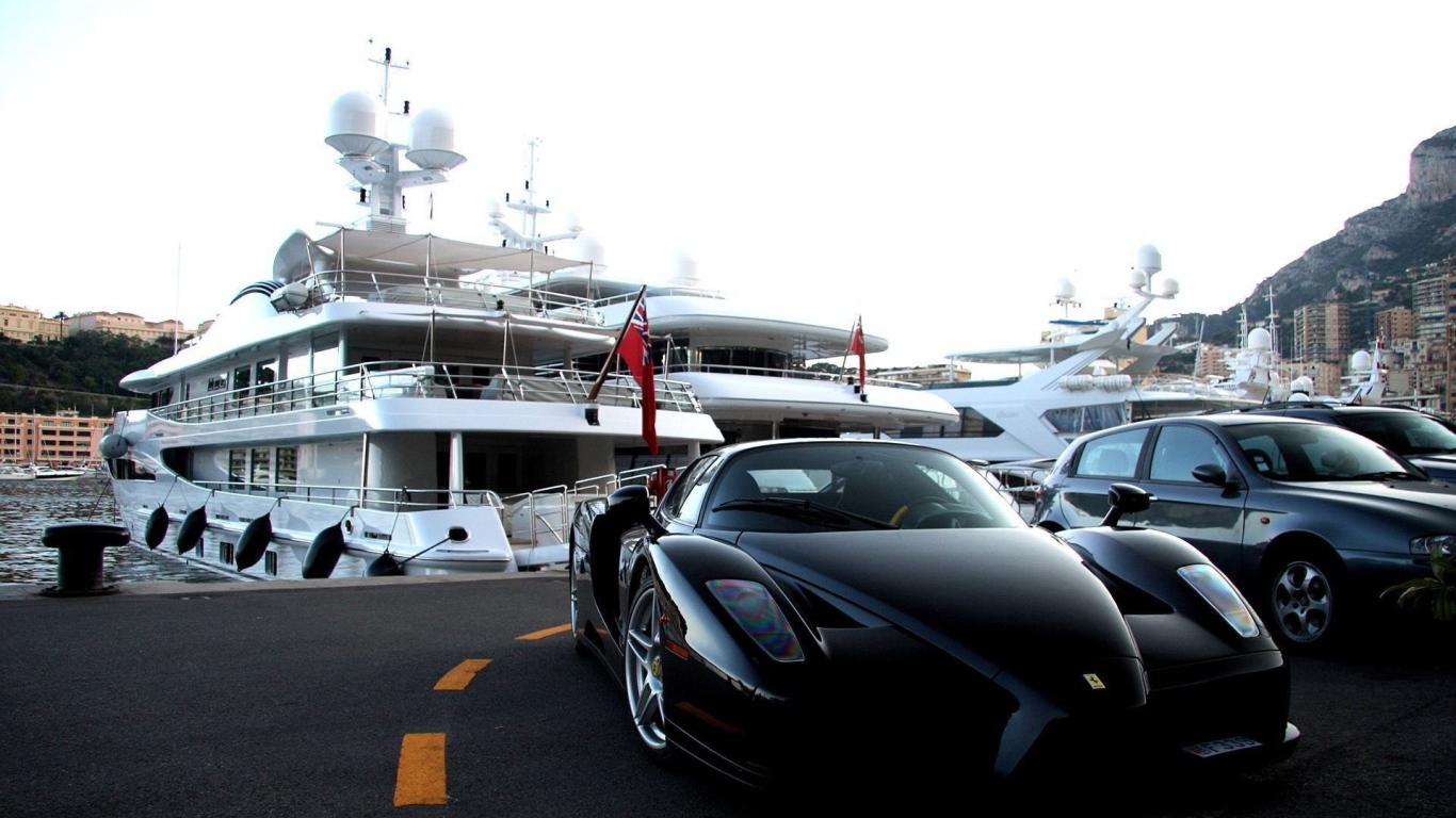 Черный Ferrari на фоне белой яхты