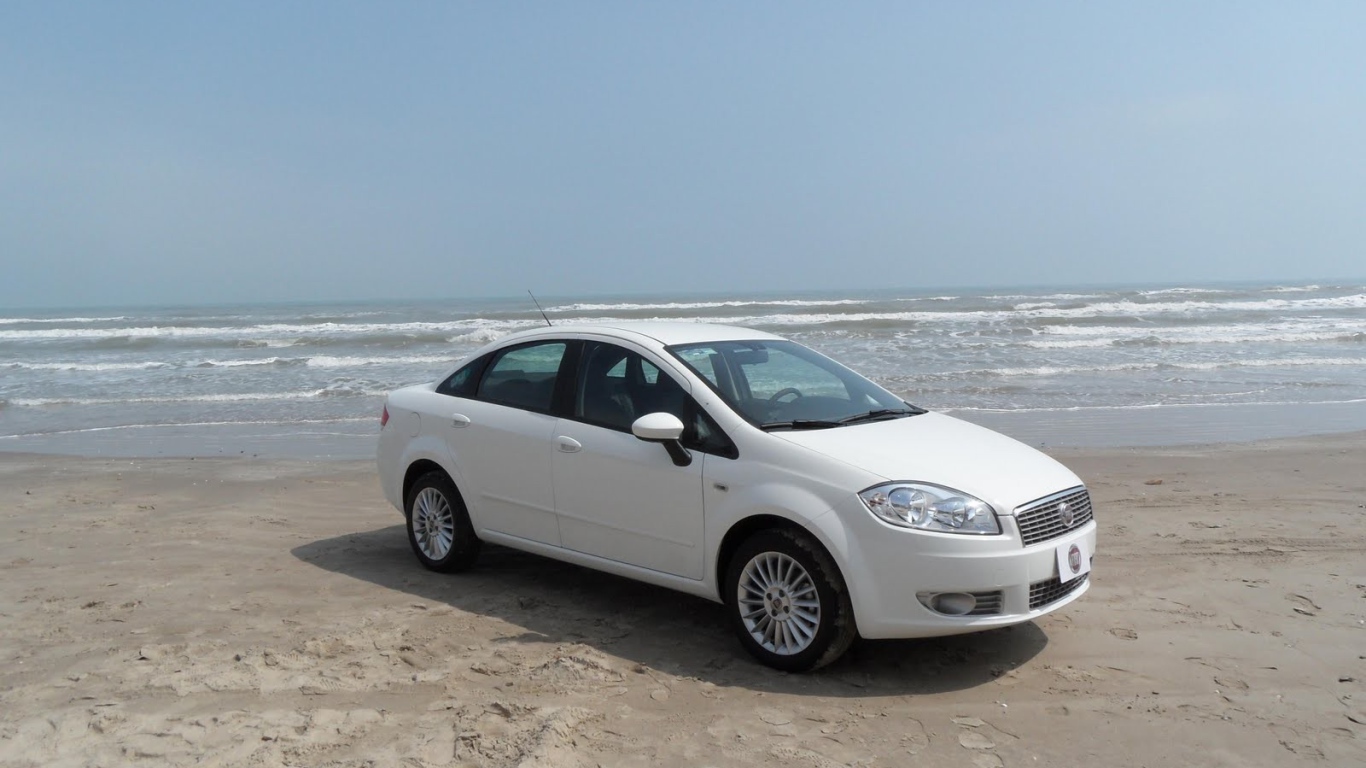 Белый Фиат на песке пляжа