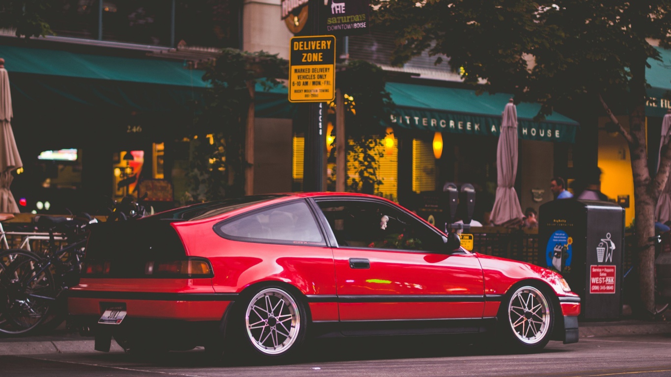 Красная Honda CRX стоит у уличного кафе
