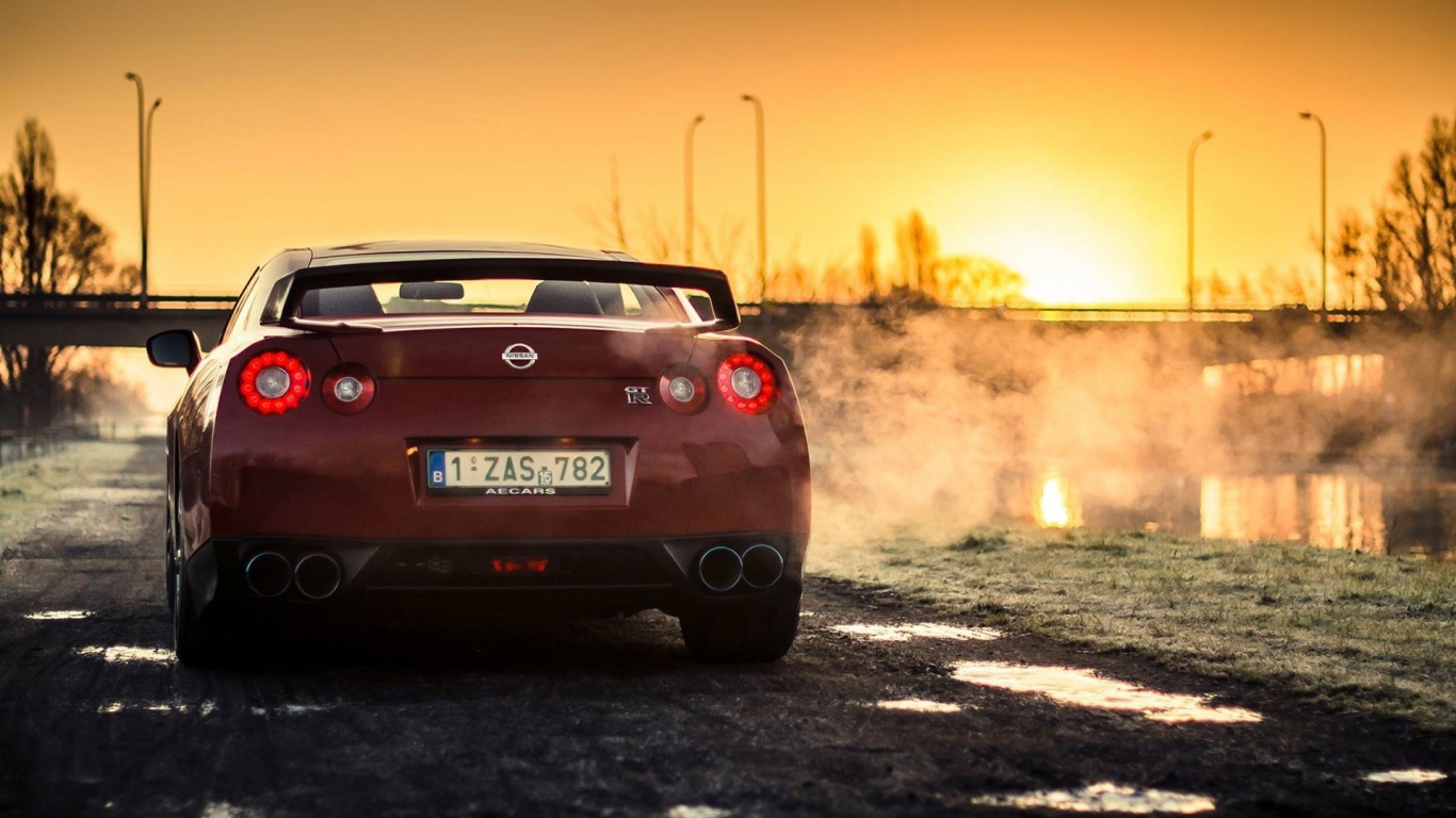 Красный Nissan у реки на рассвете