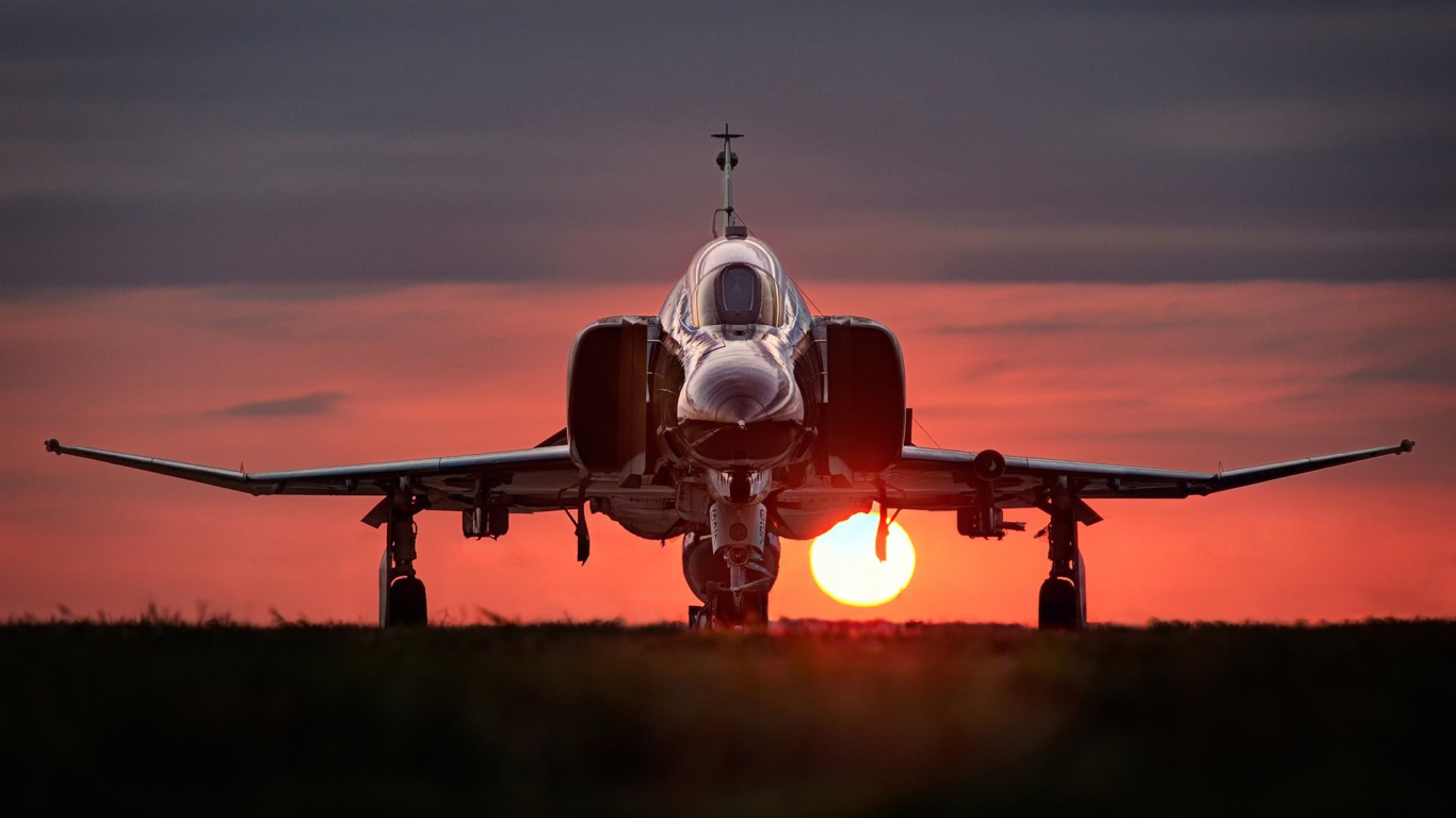 Истребитель F-4 Phantom II стоит на фоне заката