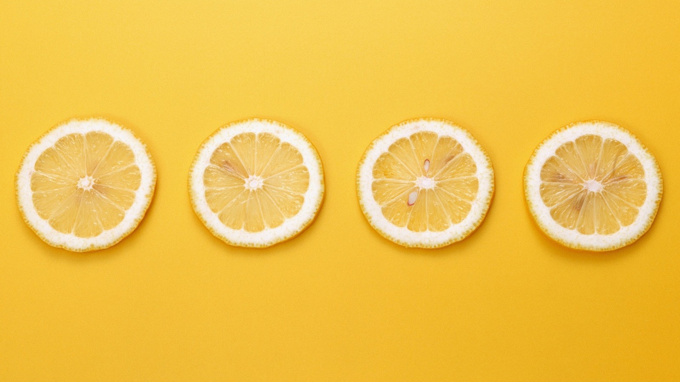 Кружки лимона, желтый фон