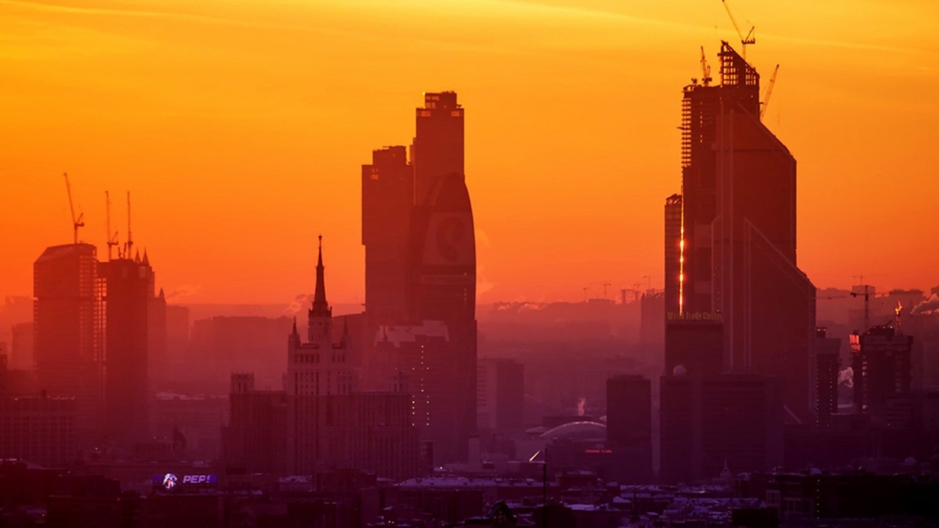 Стройка небоскребов на фоне оранжевого неба