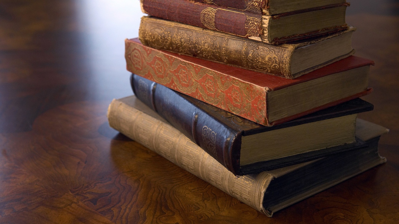 Стопка старинных книг на деревянной поверхности