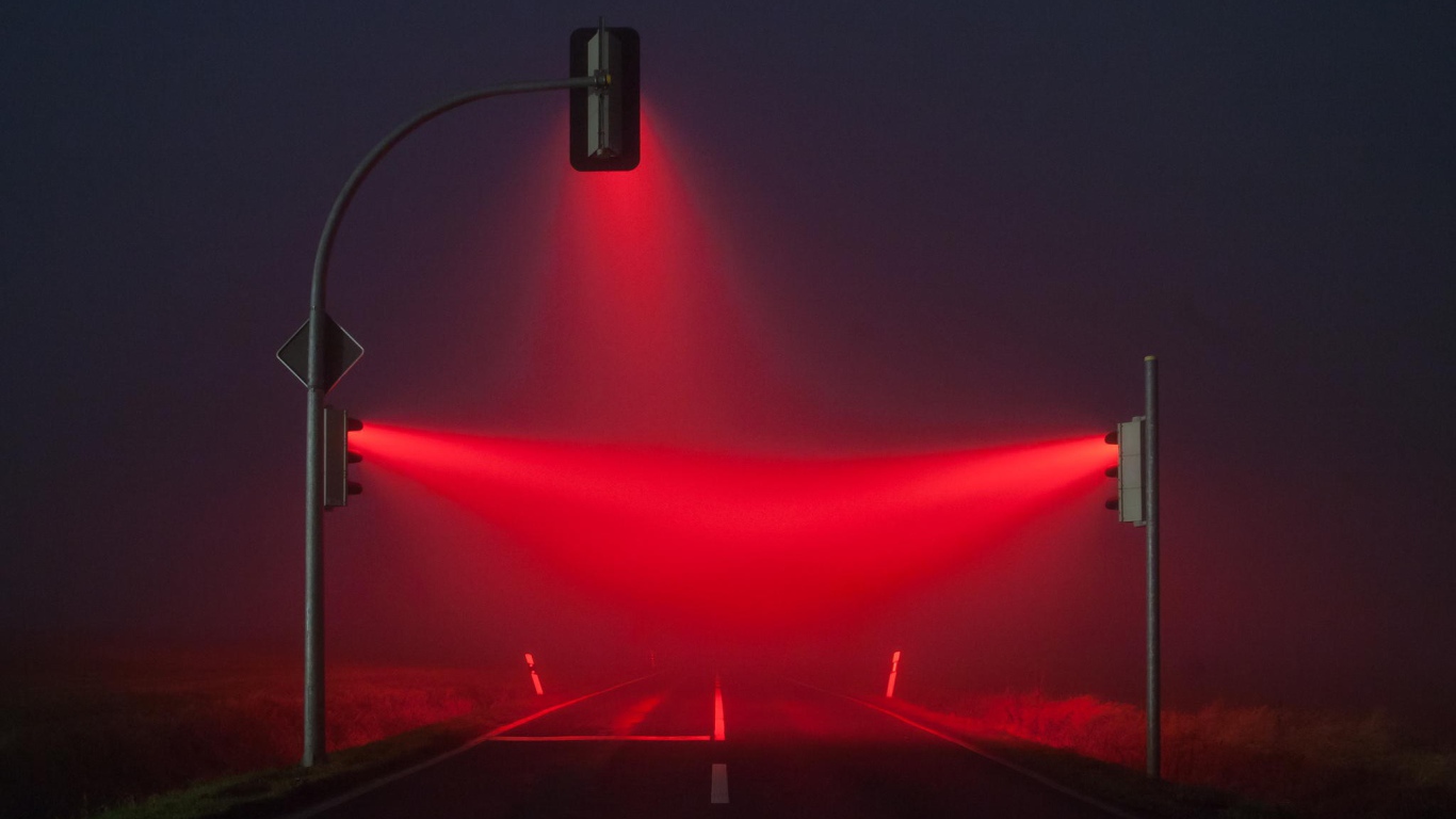 Красные светофоры освещают туман