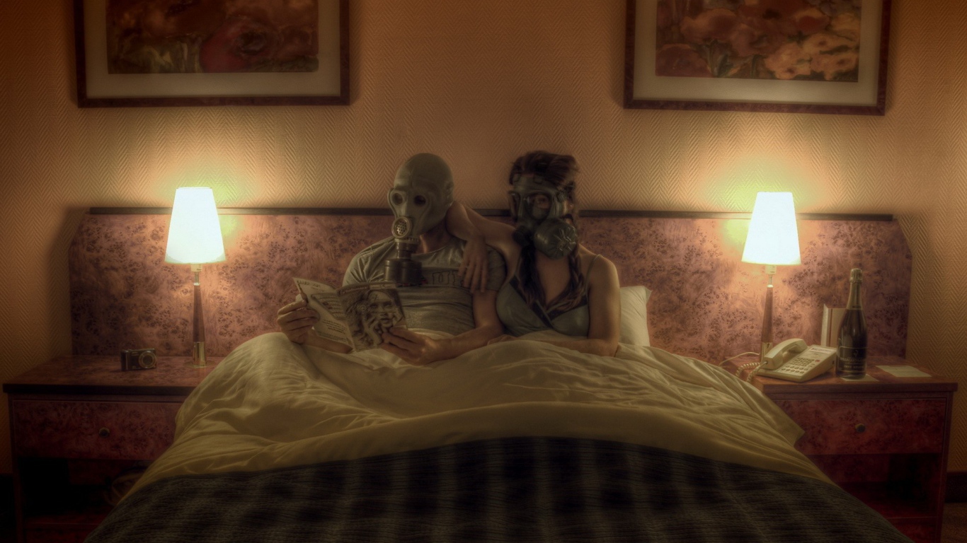 Семейная пара лежит в кровати в масках