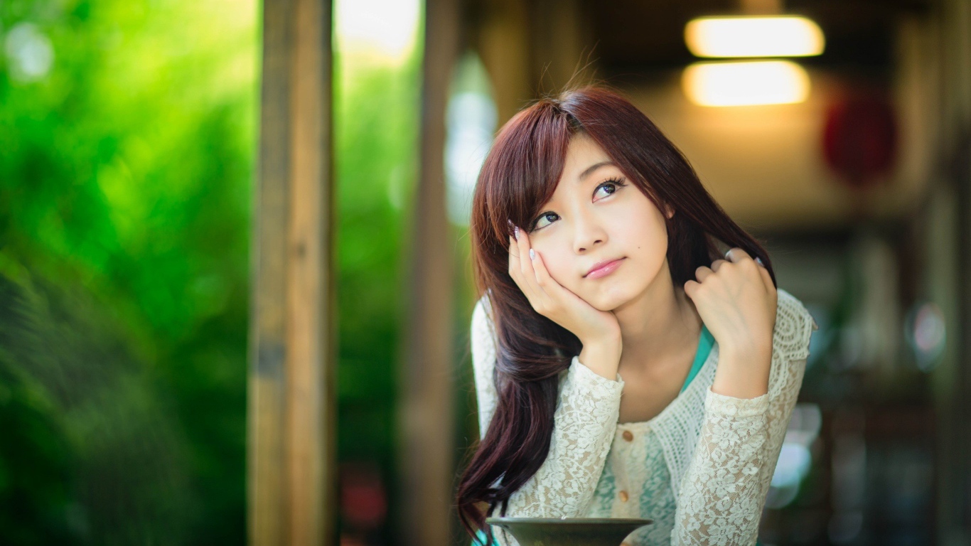 Азиатская девушка задумчиво смотрит вверх