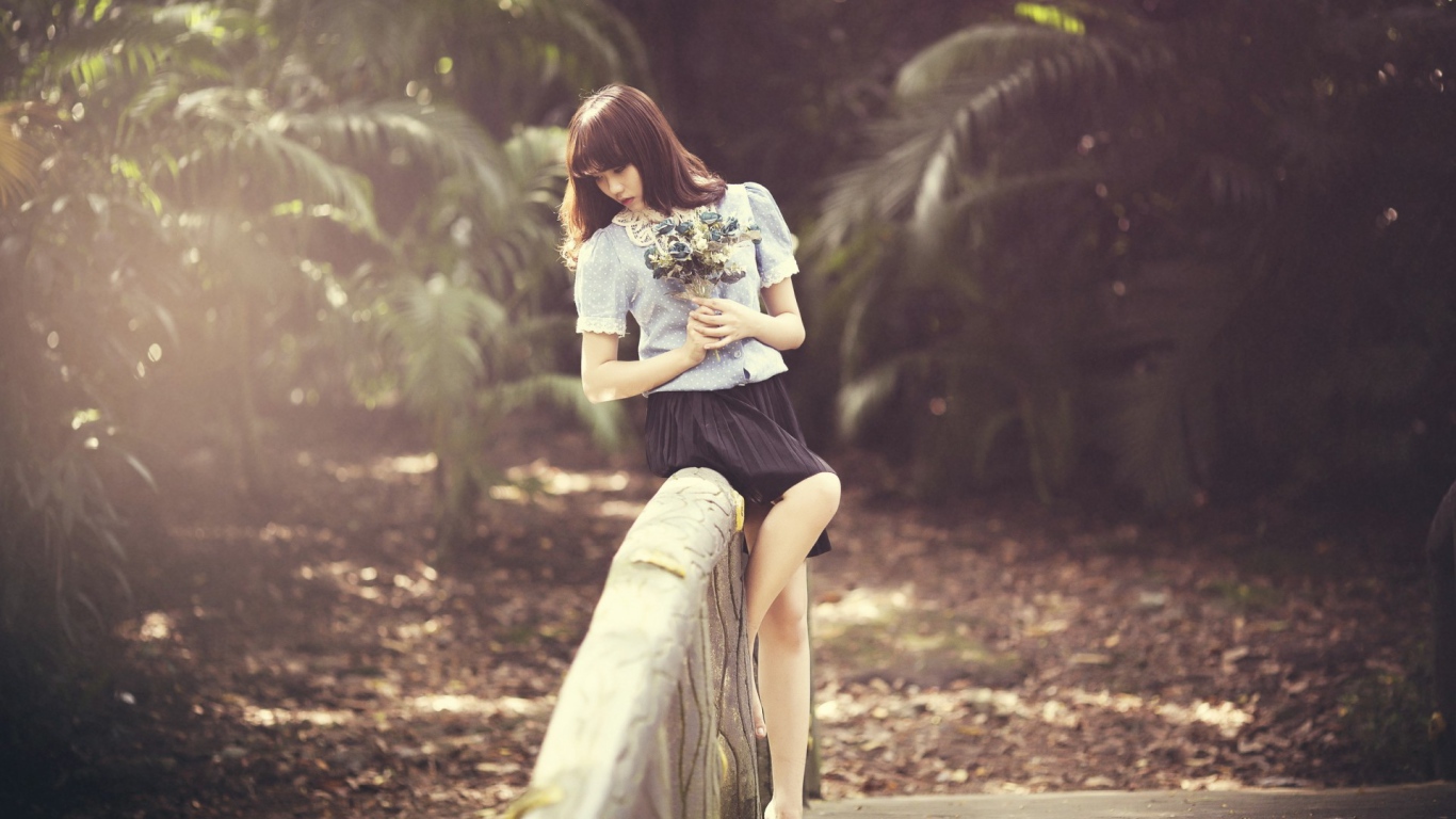 Азиатка с букетом на поручне моста