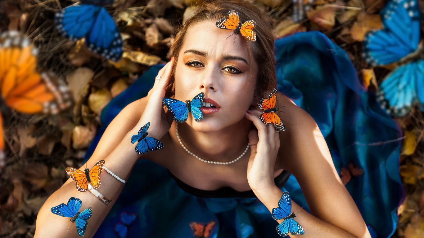 Голубые и оранжевые бабочки на девушке