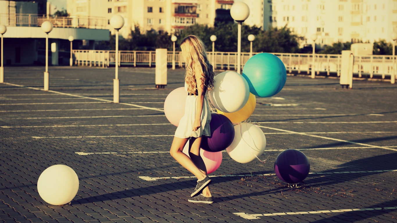 Связка воздушных шаров в руках юной девушки