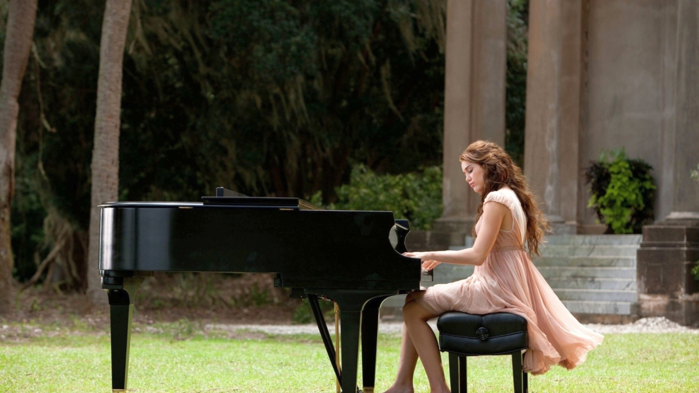 Девушка сидит за роялем на улице