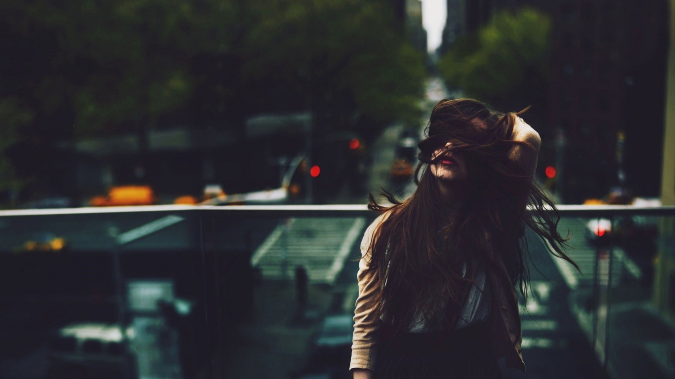 Девушка стоит на мосту над автострадой