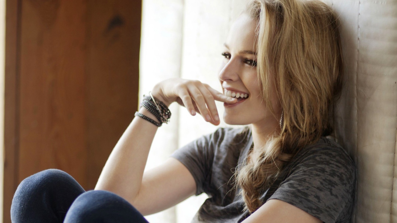 Смеющаяся блондинка приложила палец к губам