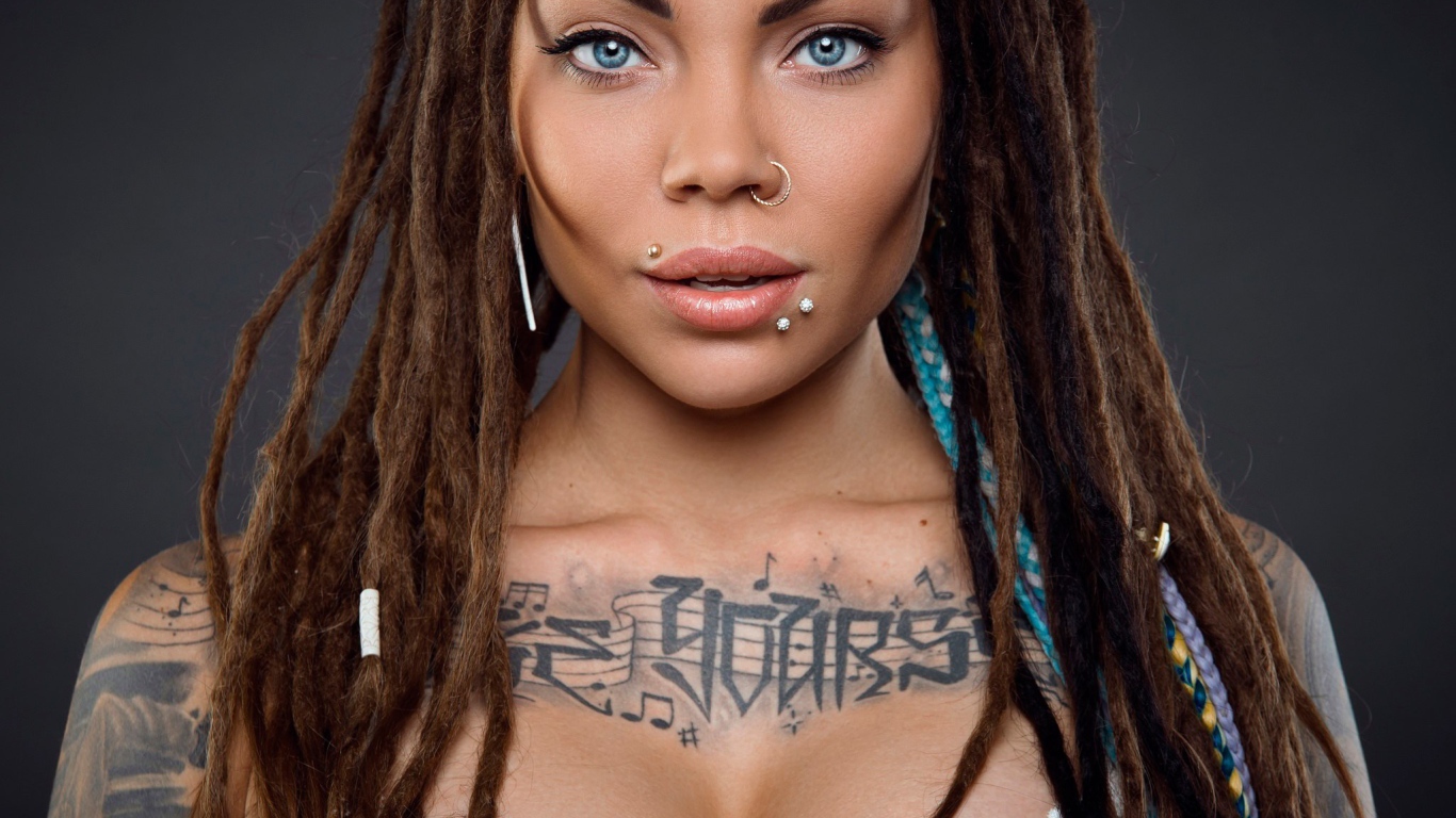 Музыкальное тату на груди у девушки с кольцом в носу