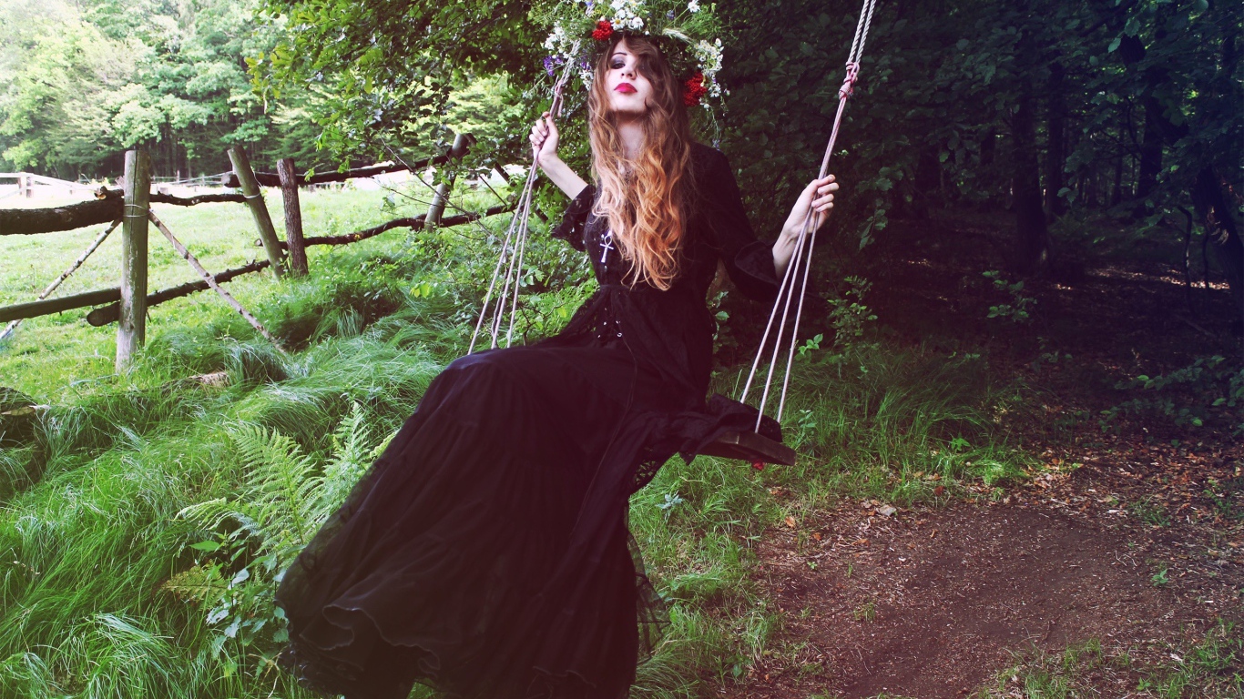 Девушка в черном платье на качели