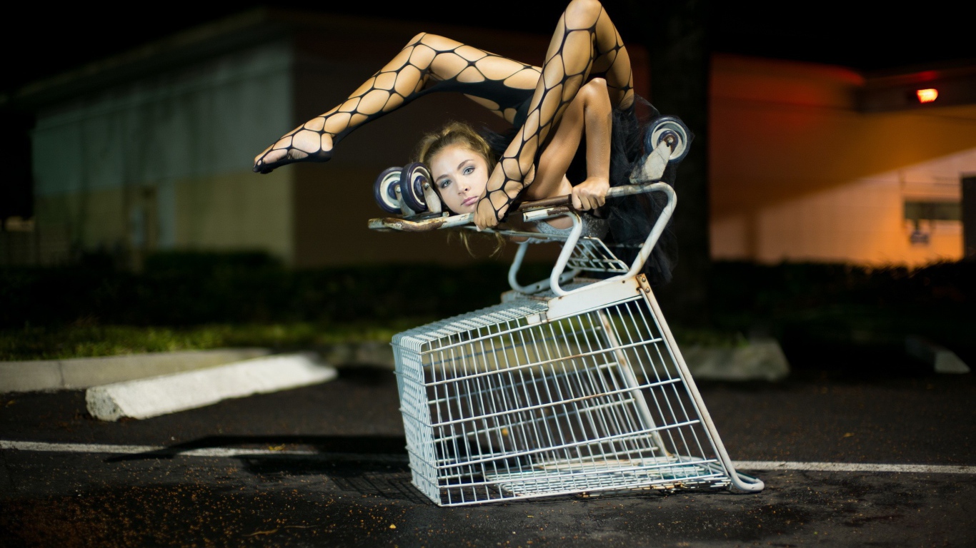 Девушка занимается йогой на корзинке из супермаркета