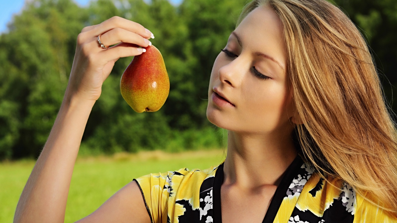 Девушка смотрит на грушу