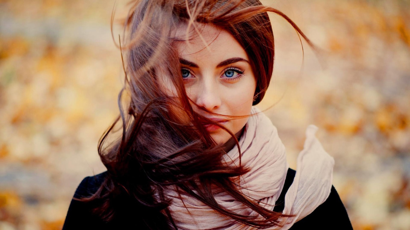 Ветер треплет волосы у девушки