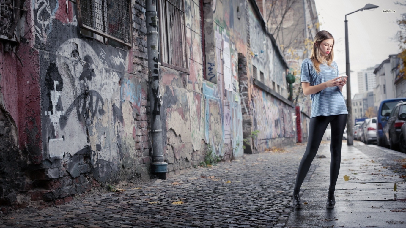 Молодая девушка стоит на улице в трущобах